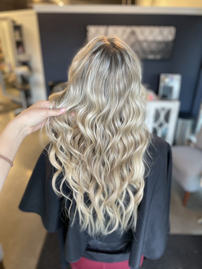 blonde woman with hair extensions at studio v hair salon in vancouver washington