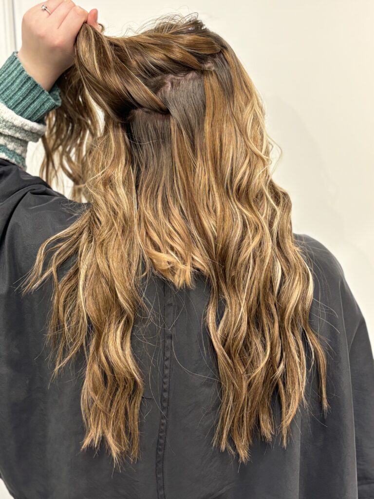 woman lifting up hand tied hair extensions